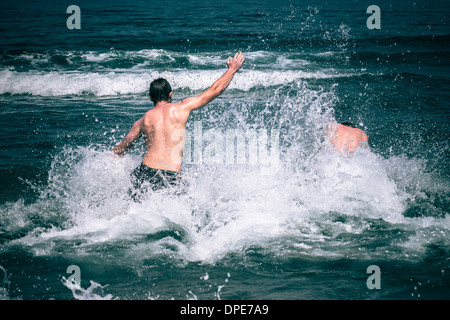 Young people jumping in to sea Stock Photo