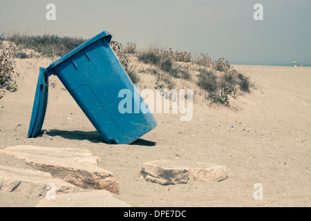 Blue plastic waste container on sandy coast Stock Photo