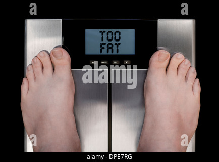 Man's Feet on Bathroom Scales on Carpet photographed from above with Display Showing TOO FAT Stock Photo