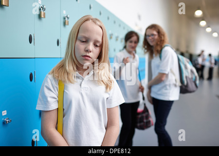 Schoolgirl being bullied in school corridor Stock Photo