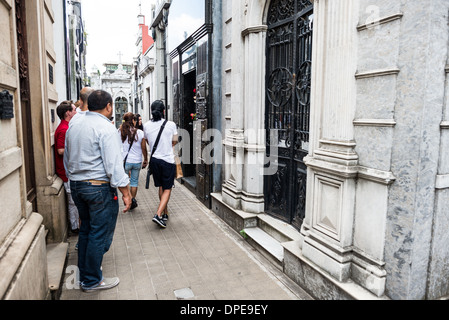 BUENOS AIRES, Argentina — Visitors gather at the Duarte family vault in Recoleta Cemetery (Cementerio de la Recoleta), paying their respects to Eva 'Evita' Perón. The tomb of Argentina's former First Lady, who died in 1952, continues to draw admirers and tourists from around the world. Fresh flowers and offerings regularly adorn this relatively modest mausoleum, demonstrating Evita's enduring impact on Argentine culture and politics. Stock Photo