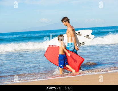 Father and Son Going Surfing Together on Tropical Beach in Hawaii Stock Photo