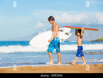 Father and Son Going Surfing Together on Tropical Beach in Hawaii Stock Photo