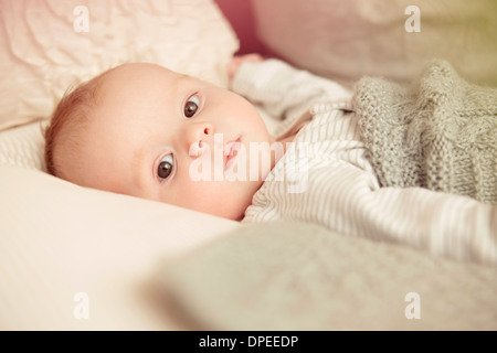 Two month old baby boy lying awake in crib Stock Photo