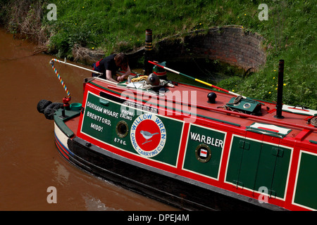 A traditional working narrowboat approaching Lock 8 of the Audlem flight of locks on the Shropshire Union Canal Stock Photo