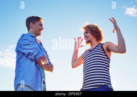 Two male friends enjoying conversation in sunlight Stock Photo