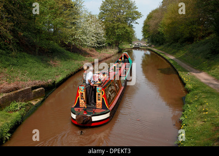 A traditional working narrowboat approaching Lock 6 of the Audlem flight of locks on the Shropshire Union Canal Stock Photo