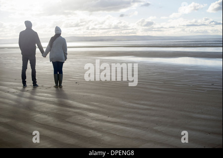 Young couple holding hands, Brean Sands, Somerset, England Stock Photo