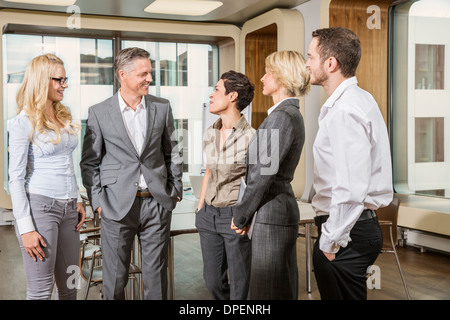 Businesspeople standing in conference room Stock Photo