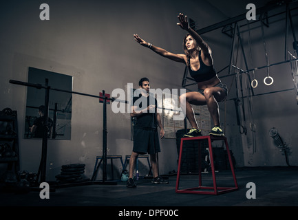 Woman training under instructor's guidance in gym Stock Photo