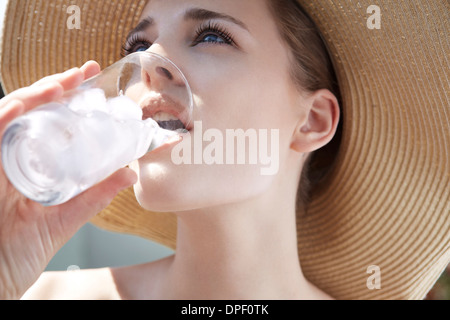 Young woman drinking from glass with ice Stock Photo