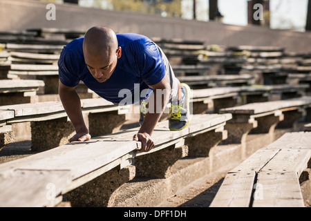 Man doing push ups on bench Stock Photo