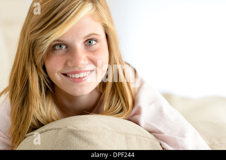 Smiling beautiful teenager girl lying on pillow looking at camera Stock Photo