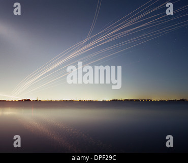 Light trails over water from airborne transport Stock Photo