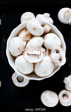 Bowl of white mushrooms on black background Stock Photo