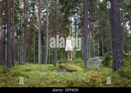 Teenage girl jumping in forest Stock Photo