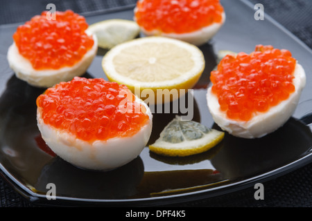 Caviar eggs on a black plate Stock Photo