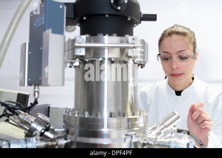 Female lab technician operating scientific equipment Stock Photo