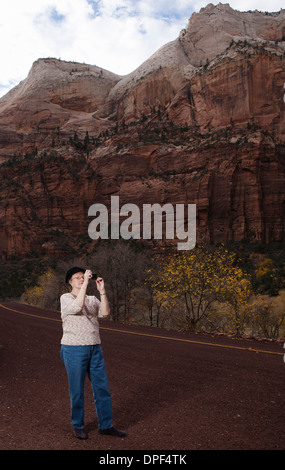 Senior woman taking photograph in Zion National Park, Utah, USA Stock Photo