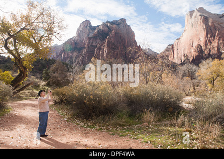 Senior woman photographing view in Zion National Park, Utah, USA Stock Photo