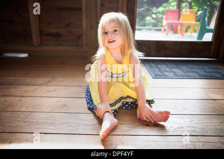 Female toddler sitting on wooden floor Stock Photo