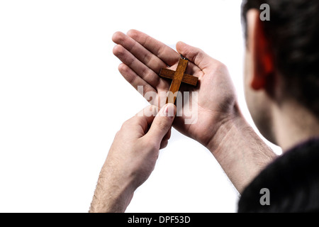 Male hands holding wooden cross on white background Stock Photo