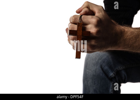 Male hands holding wooden cross on white background Stock Photo