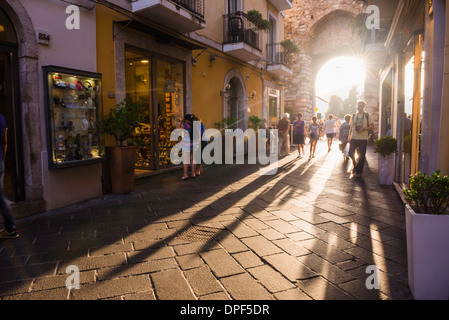 Tourists entering Corso Umberto, the main street in Taormina at sunset, Sicily, Italy, Europe Stock Photo