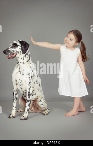 Studio portrait of female toddler and dalmatian dog Stock Photo