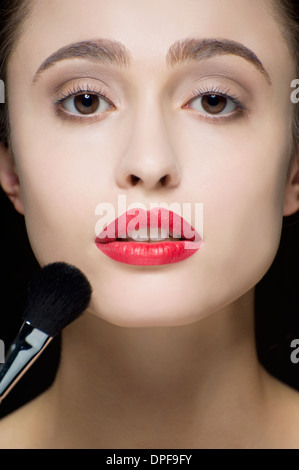 Cropped studio shot of serene young woman and make up brush Stock Photo