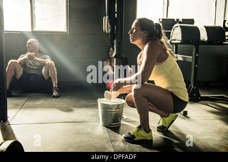 Young woman preparing hands with chalk in gymnasium Stock Photo