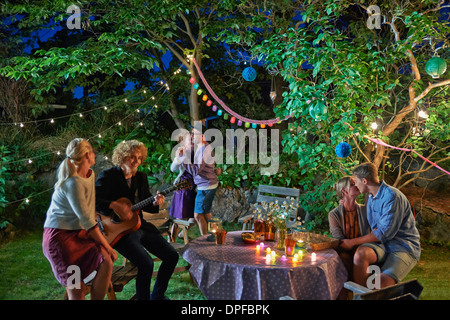 Three couples having fun at garden party at night Stock Photo