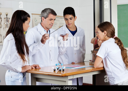 Professor Experimenting In Front Of Students At Desk Stock Photo