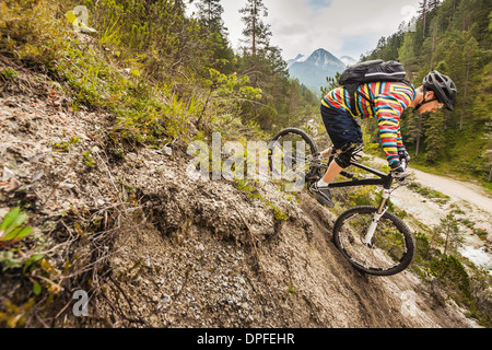 Mountain biker riding down mountain Stock Photo