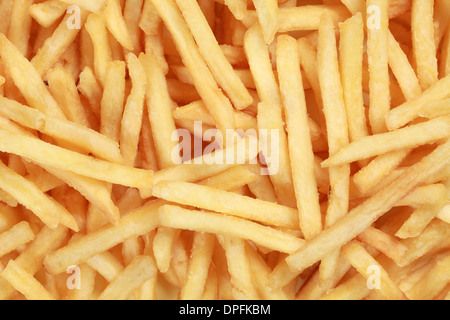 Fresh French fries forming a fast food background Stock Photo