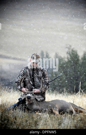Deer hunter holding up dead stags antlers, John Day, Oregon, USA Stock Photo