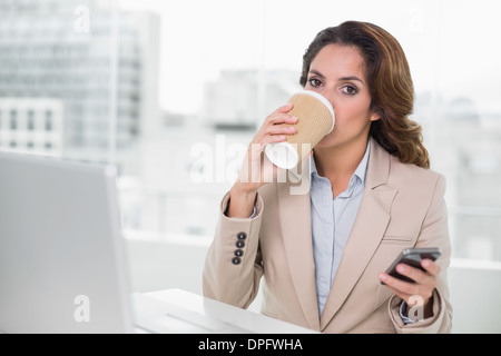 Attractive businesswoman drinking from disposable cup Stock Photo