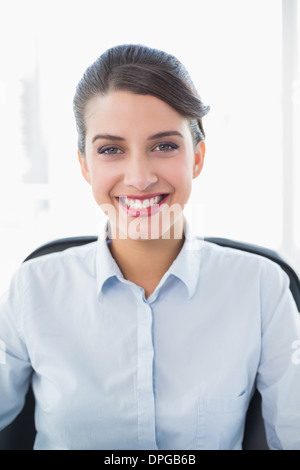 Content classy brown haired businesswoman looking at camera Stock Photo