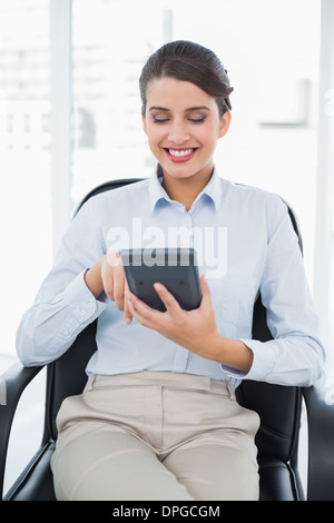 Content classy brown haired businesswoman using a calculator Stock Photo