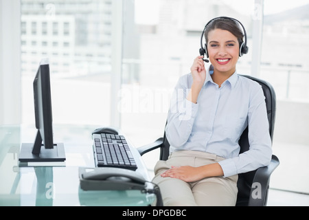 Smiling classy brown haired operator answering a call Stock Photo