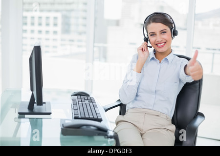 Cheering classy classy brown haired operator raising her thumb Stock Photo