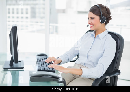 Cheerful classy brown haired operator using her computer Stock Photo