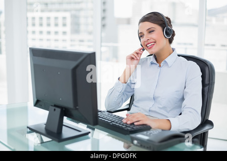 Joyful classy brown haired operator answering a call Stock Photo