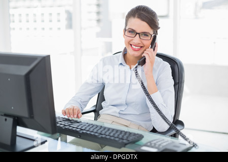 Content classy brown haired businesswoman answering the telephone Stock Photo
