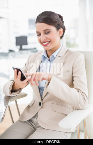 Joyful smart brown haired businesswoman using a mobile phone Stock Photo