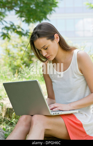 Woman using laptop computer outdoors Stock Photo