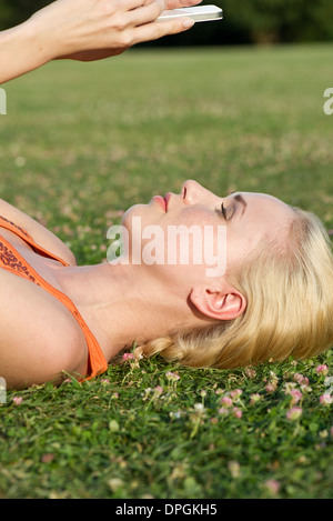 Young woman lying on grass using smartphone Stock Photo
