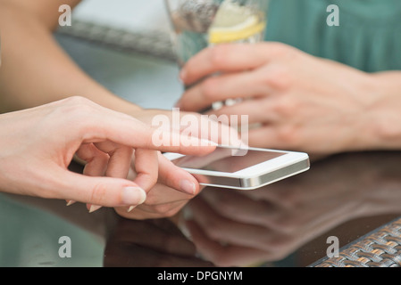 Friends looking at smartphone together Stock Photo