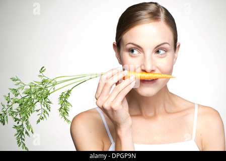 Young woman smelling carrot Stock Photo