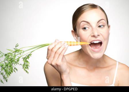 Young woman eating carrot Stock Photo